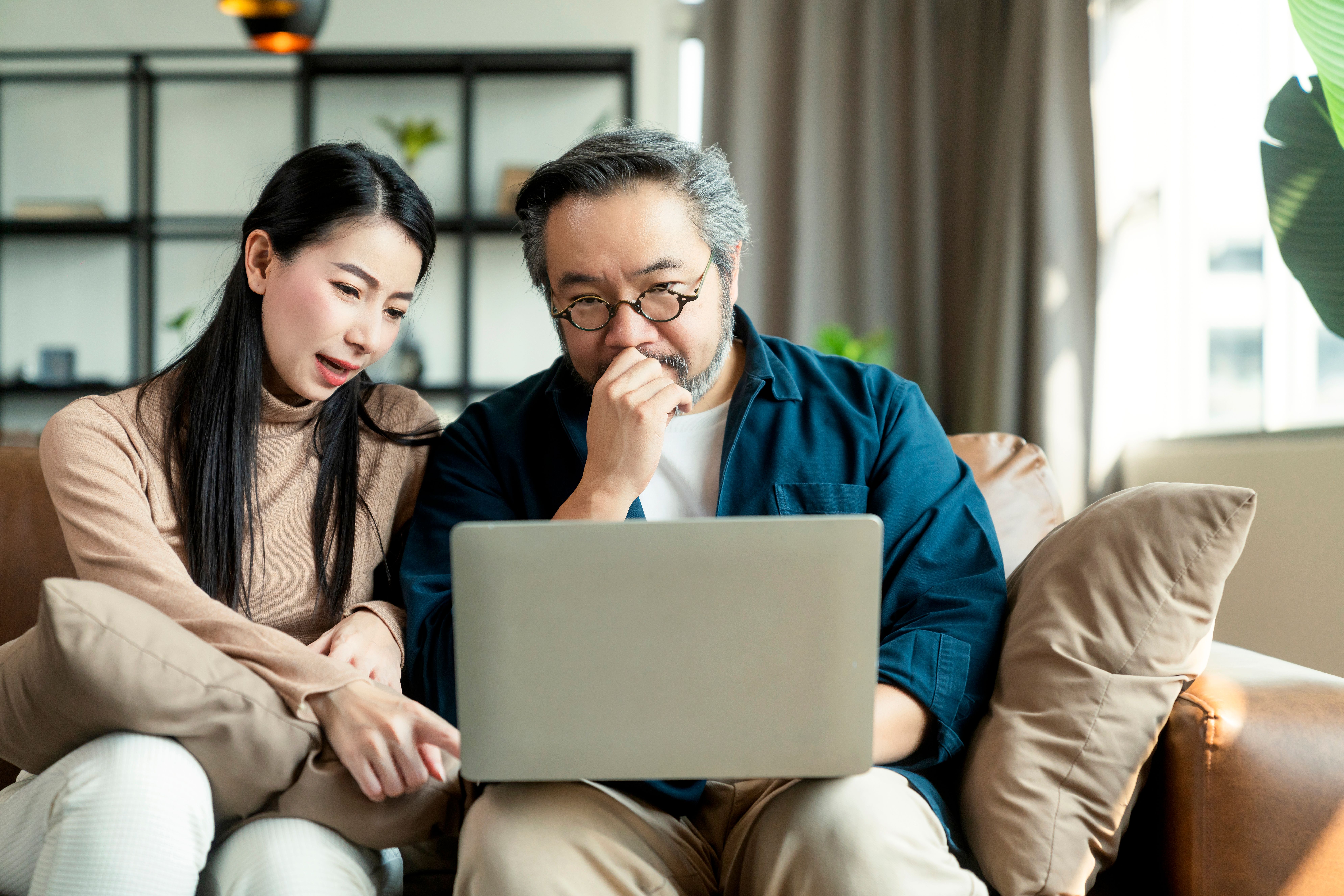 marry-asian-couple-home-finances-reviewing-their-bank-money-accounts-using-laptop-calculator-living-roomasian-couple-sitting-sofa-with-laptop-stressful-emotion-home.jpg